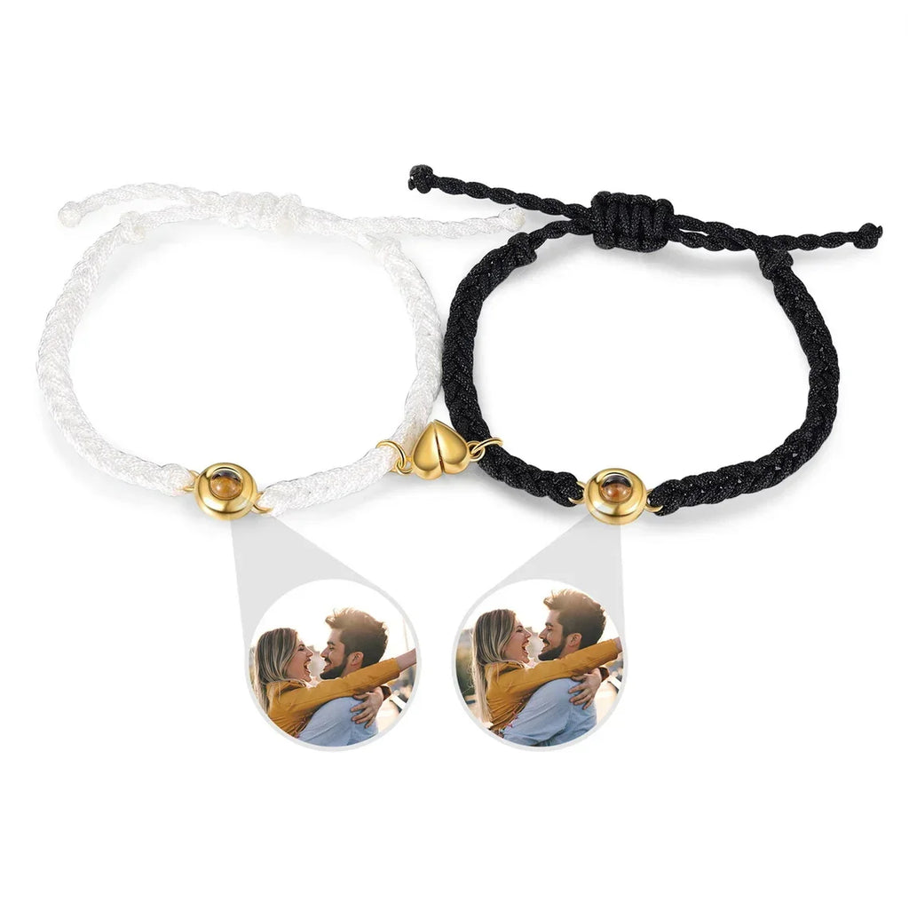 Gold-toned black and white braided bracelets with magnetic heart charms and photo projection beads