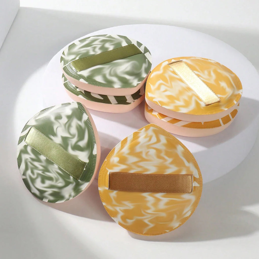 A collection of colorful marbled cosmetic sponges with ribbons for makeup application