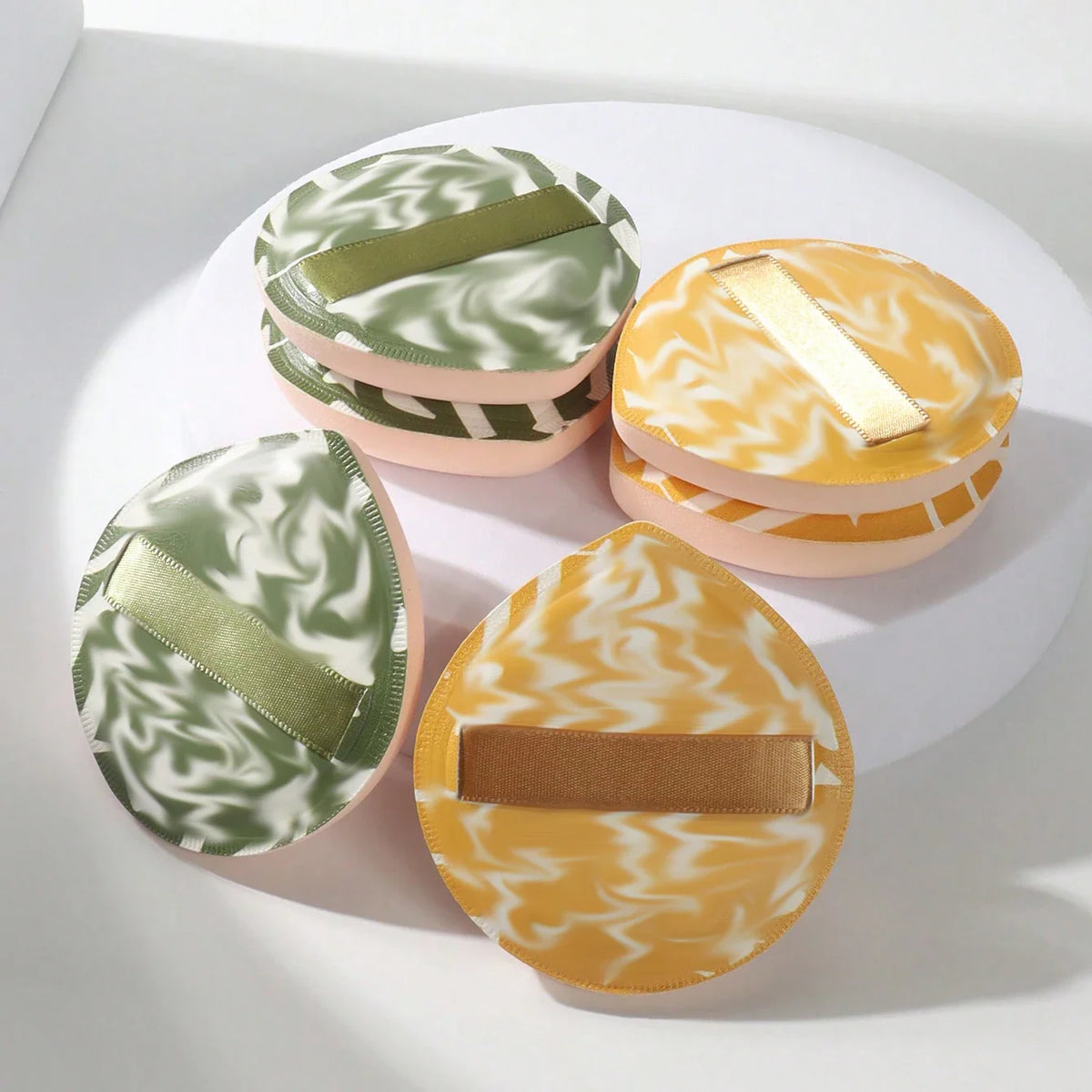 A collection of colorful marbled cosmetic sponges with ribbons for makeup application