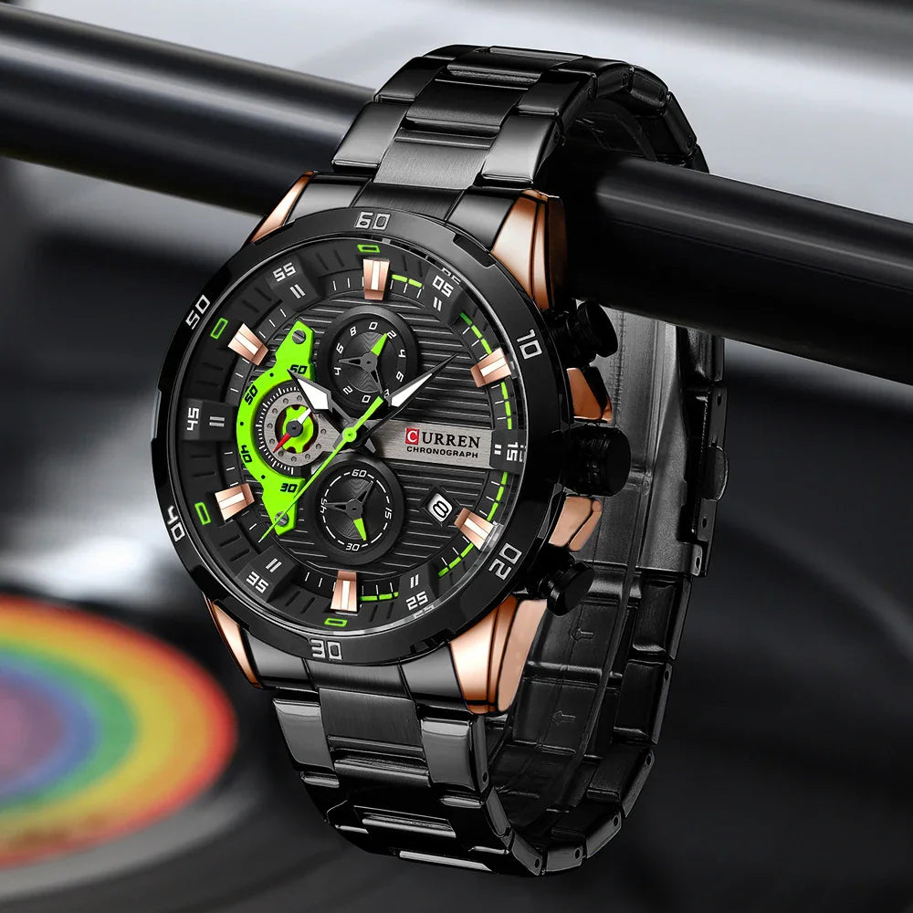 Black stainless steel chronograph watch with a black and green dial on a dark background.