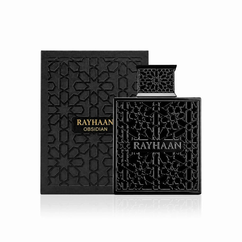 Black glass perfume bottle next to its matching decorative product box