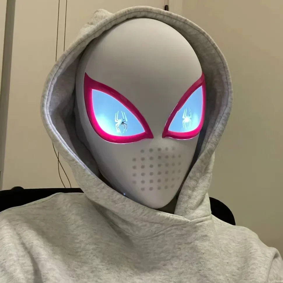 Person wearing a white superhero mask with glowing eyes and a grey hoodie.