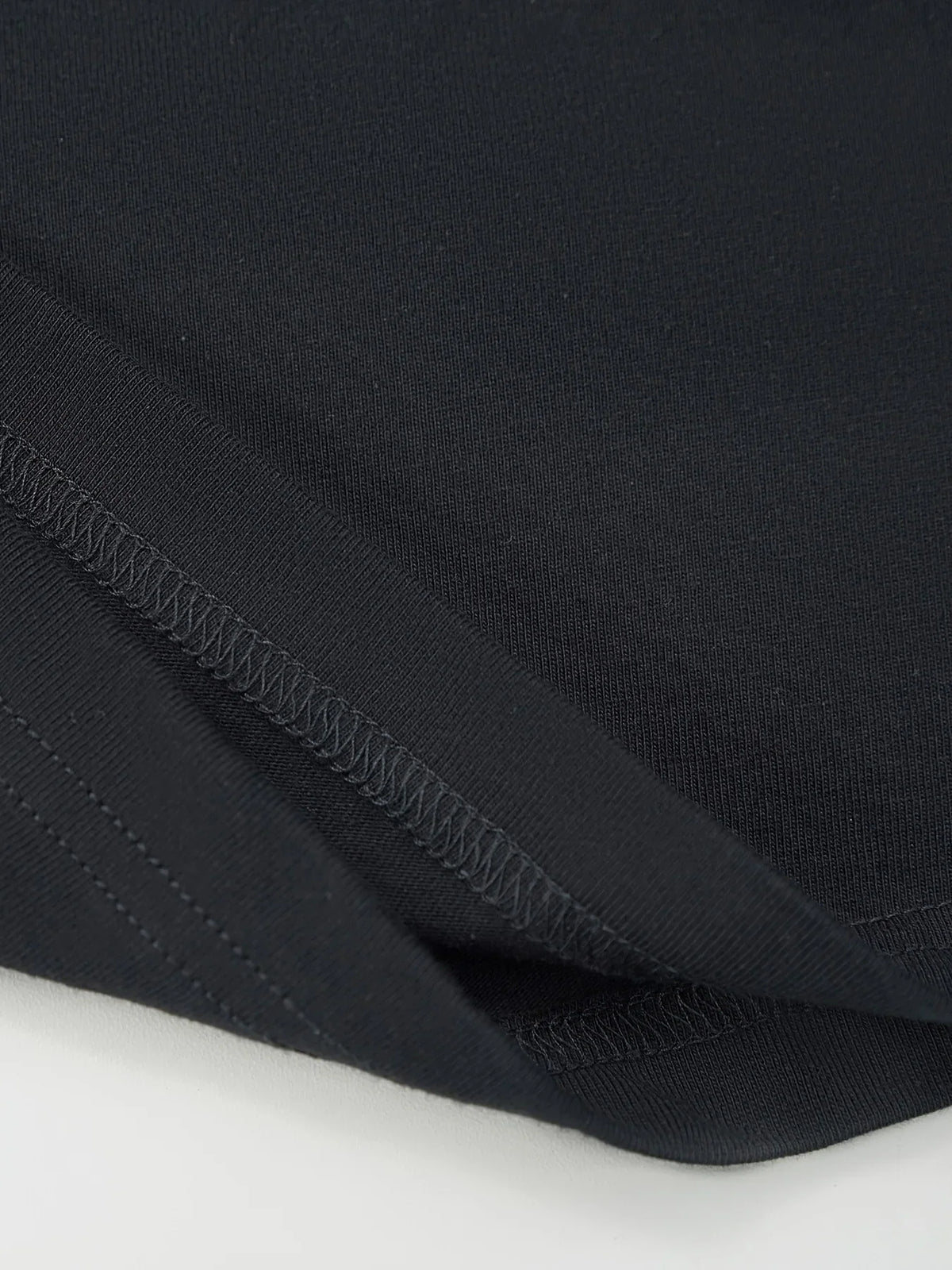 Close up of the fabric and hem of a black T-shirt