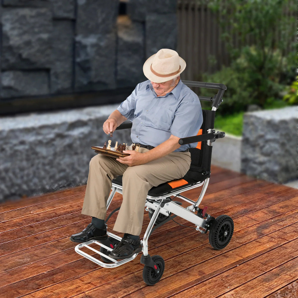 Senior man wearing a hat sitting on a portable wheelchair outdoors playing chess