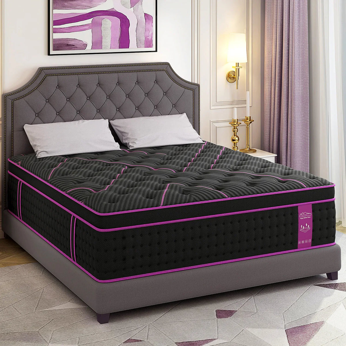 A thick hybrid mattress with a black and purple cover on a grey tufted bed frame.