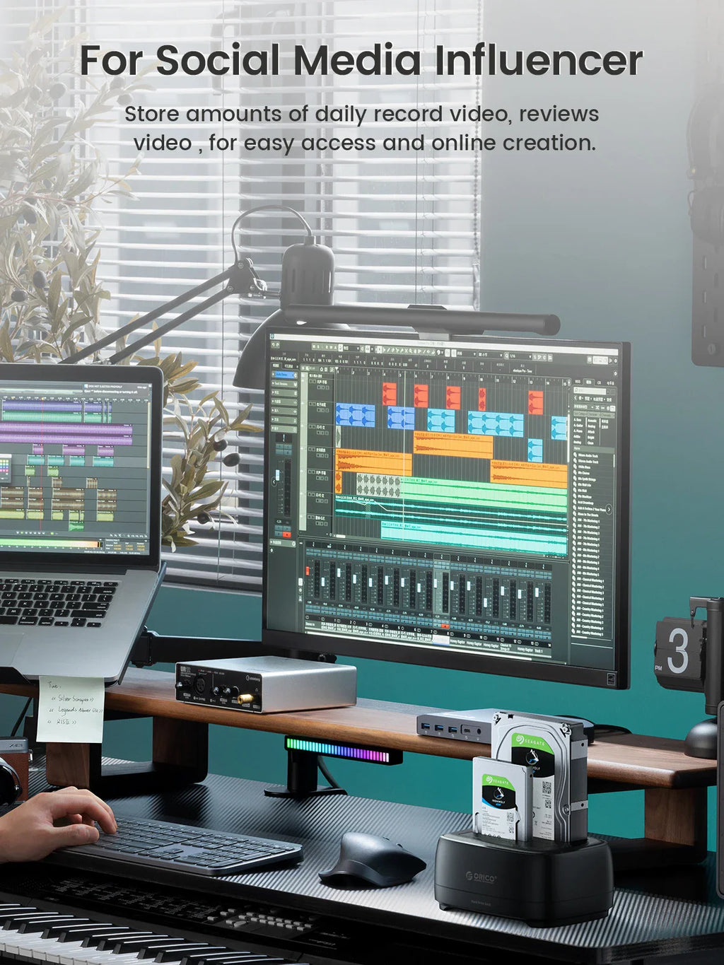 Hard drive docking station in a creative workstation setting with monitors and keyboard