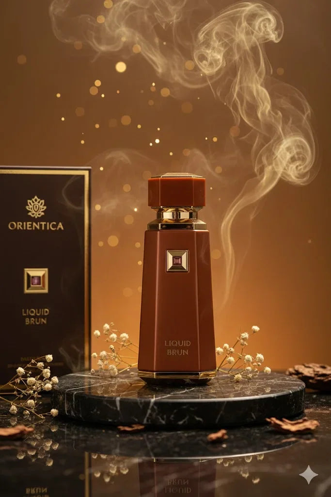 Brown perfume bottle with gold cap next to its box and baby's breath flowers