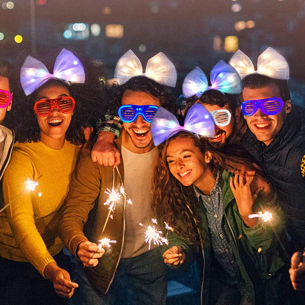 A group of friends wearing glowing LED bow headbands and party glasses at night