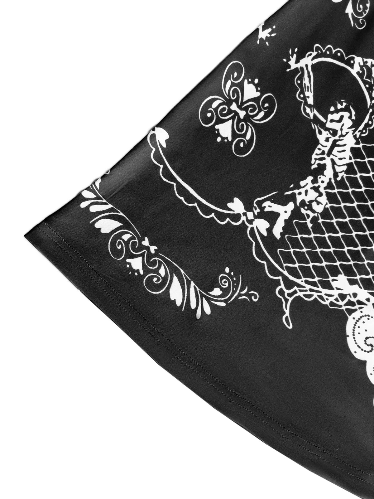 Close-up of the hem of a black dress featuring a white skeleton and ornamental gothic print