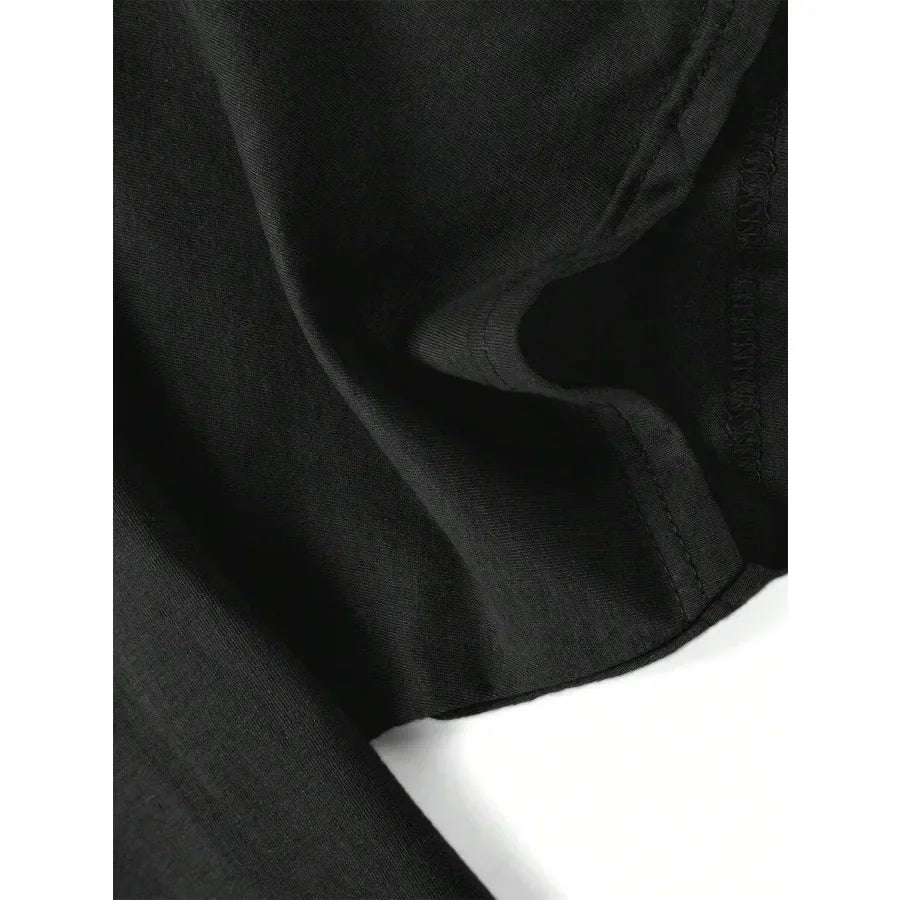 Detail of the sleeve hem and stitching of a black t-shirt.