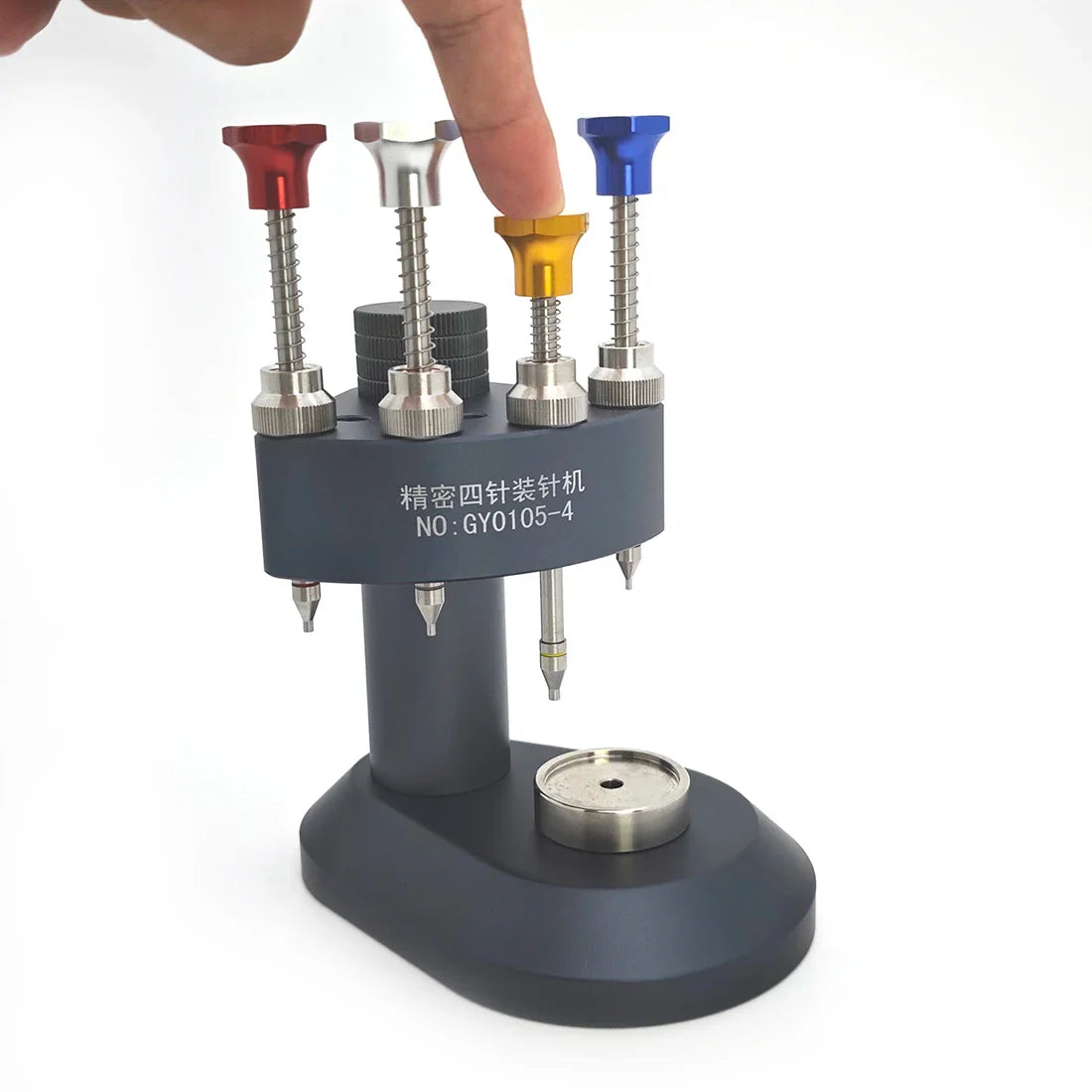 Hand pressing down on a colored pin of a watch hand installation tool