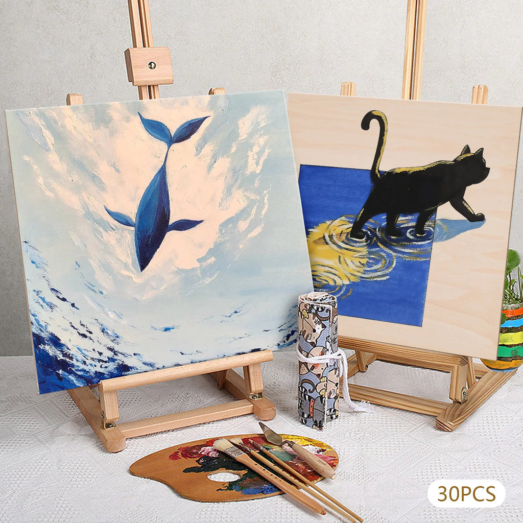 Two square wooden boards with paintings on small easels with art supplies