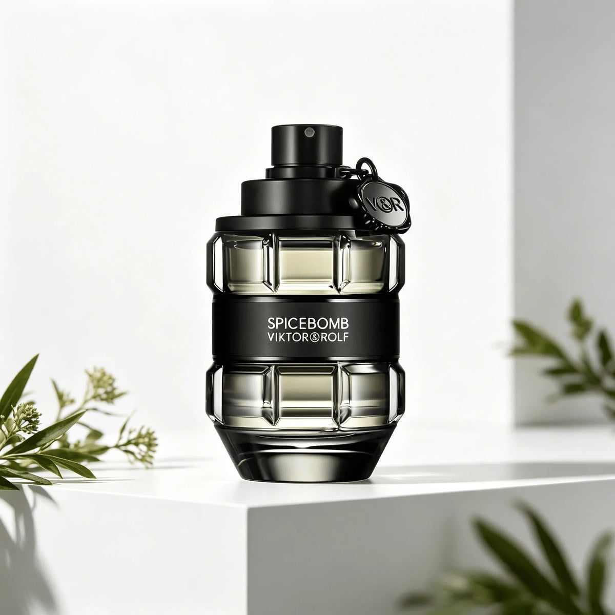 A glass perfume bottle shaped like a grenade, in a transparent black finish with a black band, on a white pedestal with