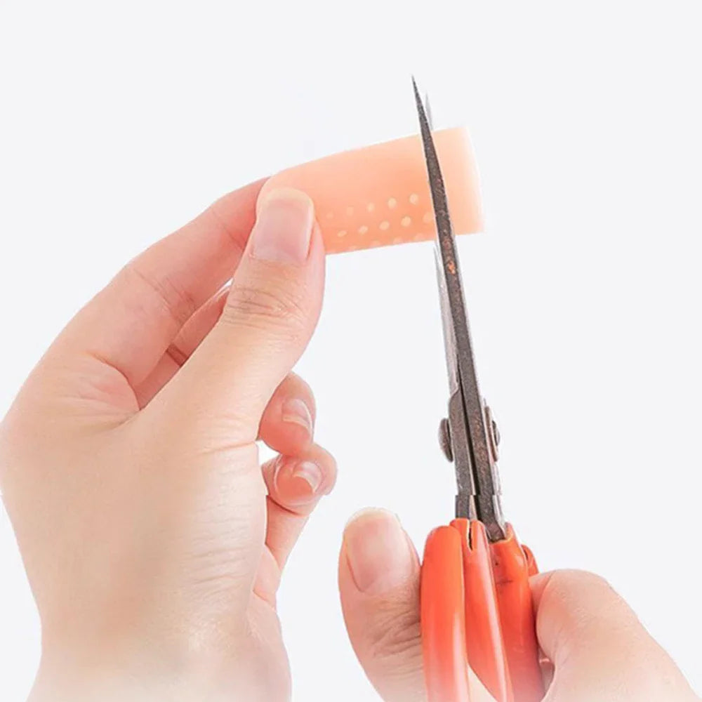 Hand using scissors to trim a flexible silicone finger protector sleeve
