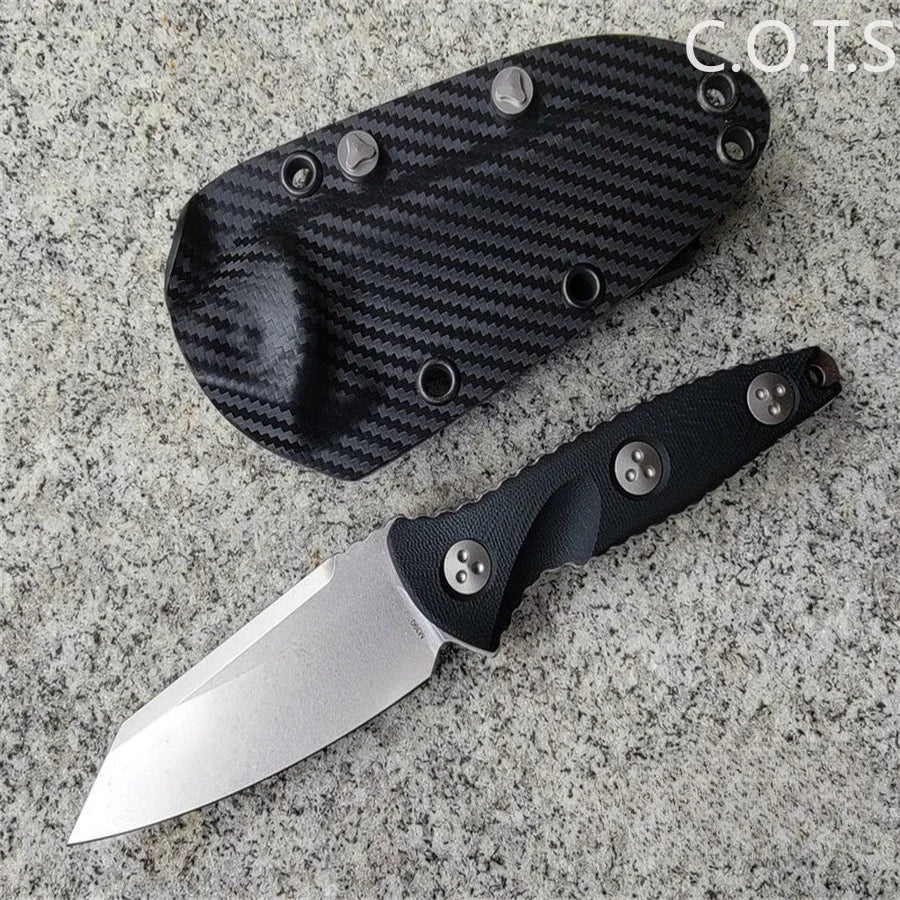 Fixed blade knife with carbon fiber patterned Kydex sheath on a textured stone surface.