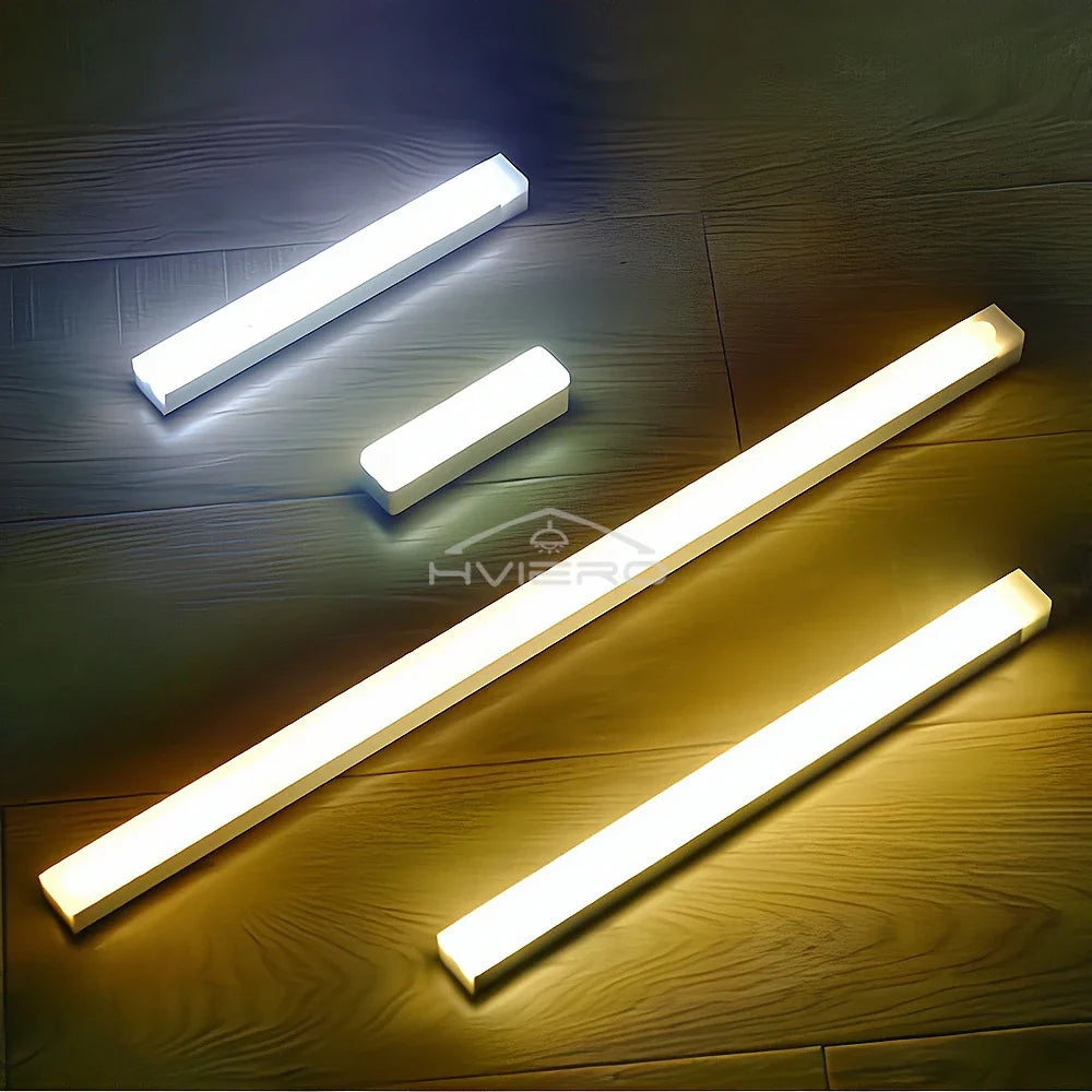 Multiple white and warm light LED strips of different lengths on a wood surface
