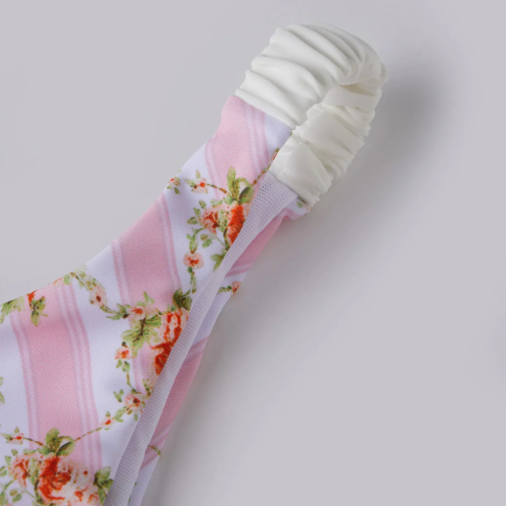 Side view of bikini bottom with white elastic side straps and floral striped pattern