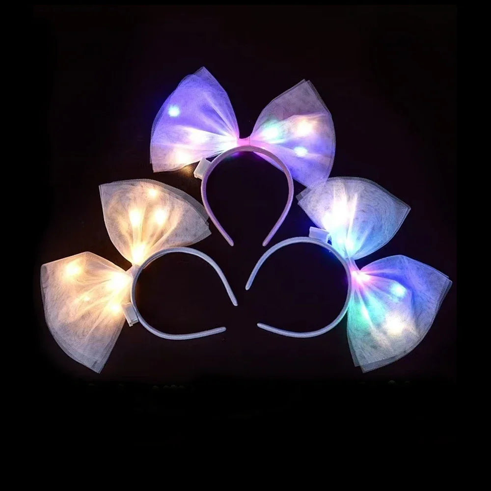 A collection of three different LED glow-up bow headbands arranged on a dark background