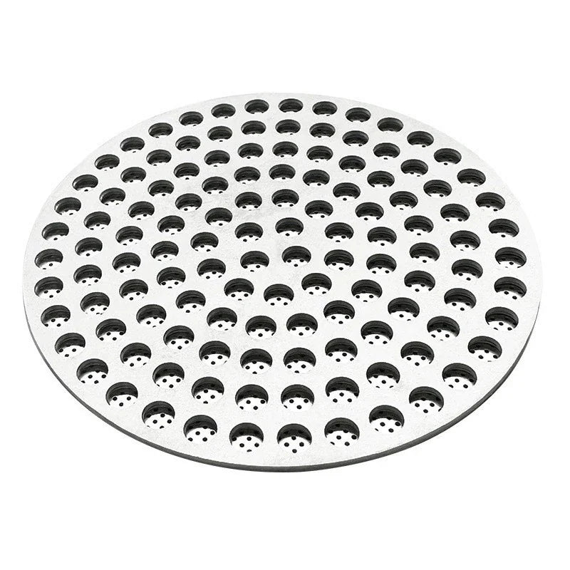 Close up view of a circular stainless steel coffee puck screen with uniform perforation