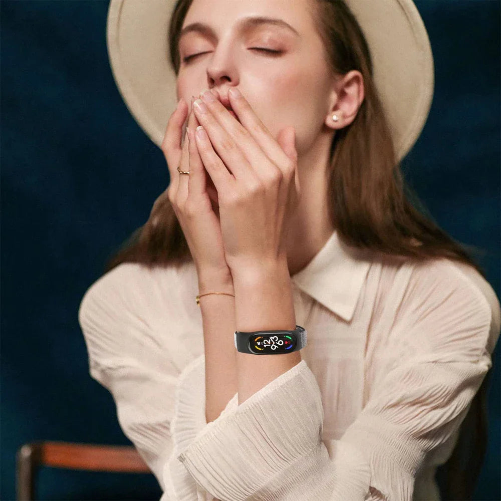 Person wearing a black nylon watch band on their wrist while holding their hands up