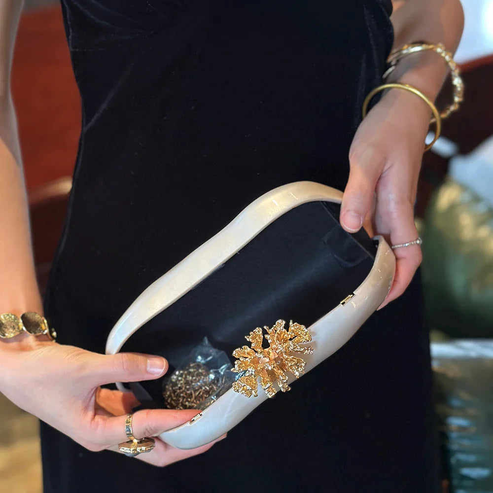 Open white marbled acrylic evening clutch showing interior chain strap