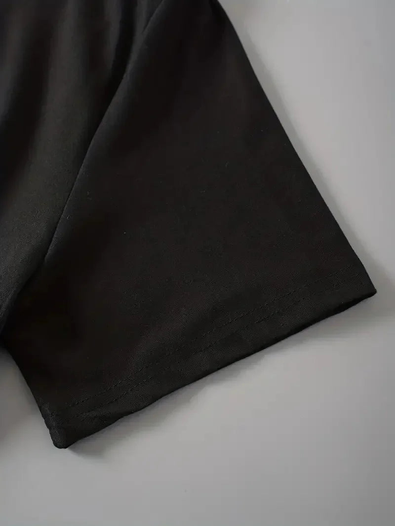 Close up shot of the black fabric of a short sleeve on a t-shirt.