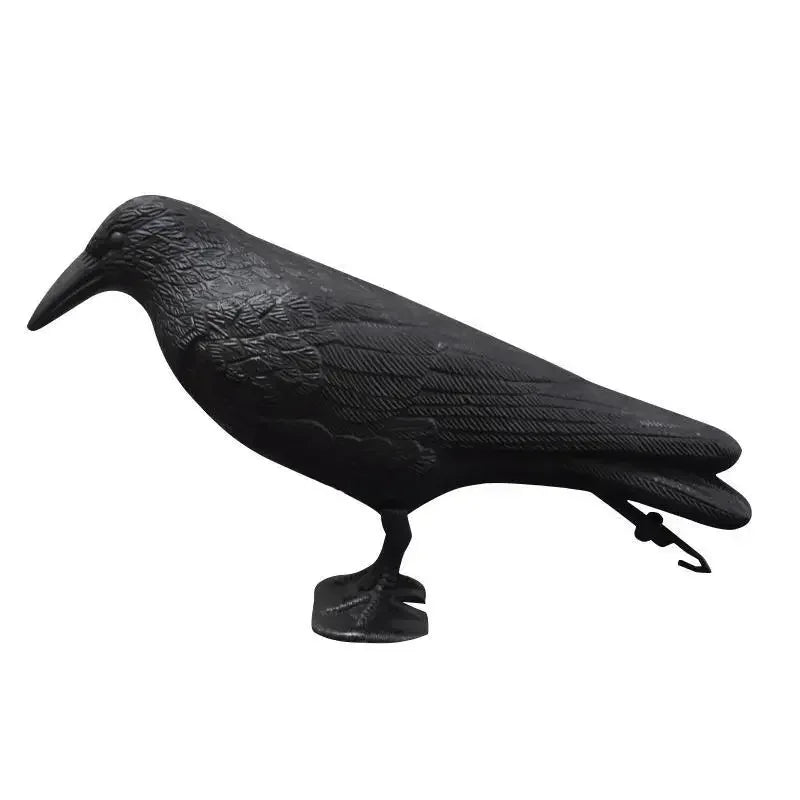 A black crow bird repellent decoy standing on a flat surface, featuring realistic feather detailing and size. – black
