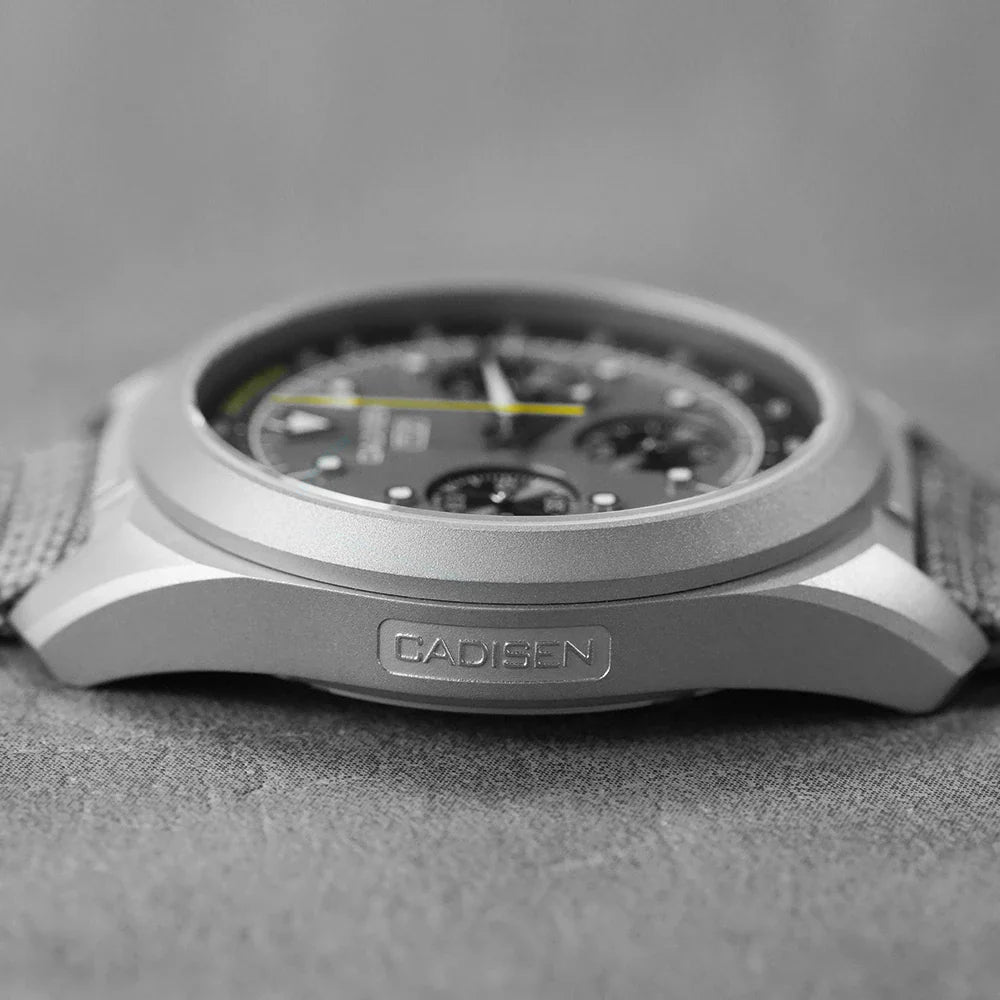 Profile view of a titanium chronograph watch case with a canvas strap