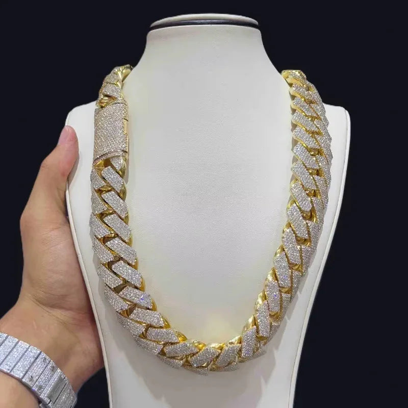 Iced out gold tone Cuban link necklace on a jewelry display bust with a hand visible