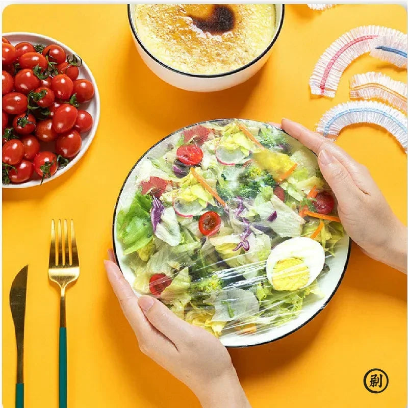 A bowl of salad being sealed with a disposable elastic food cover