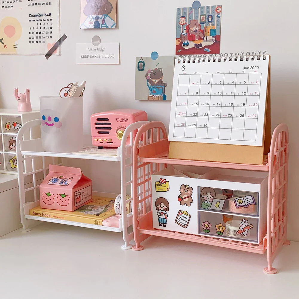 Two-tier plastic desk storage shelves in pink and white with stationery
