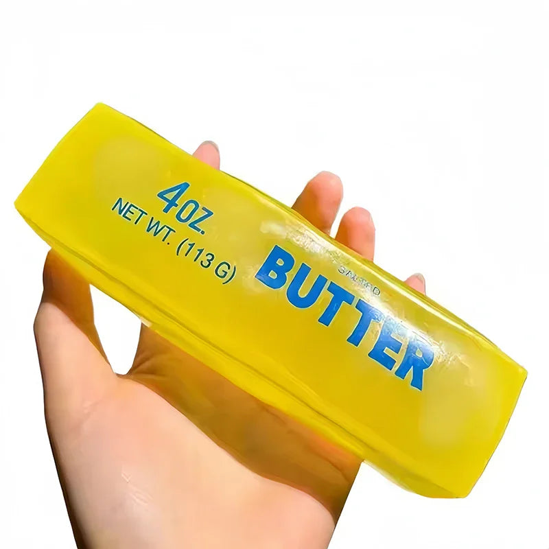 Hand holding a single yellow butter stick shaped squishy fidget toy