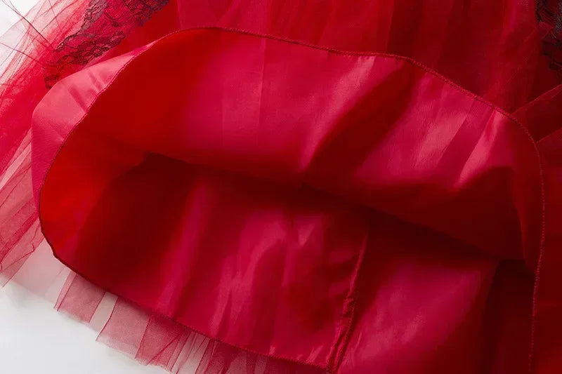 Close-up of the red fabric and black lace trim layers on a dress skirt