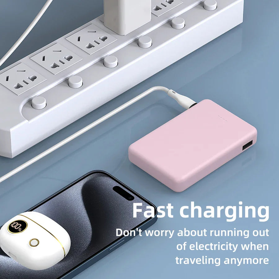 A pink power bank plugged into a wall outlet, and a wireless earbud case on a phone.