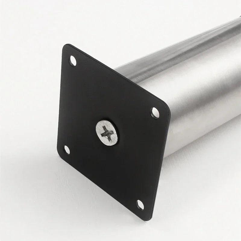 The underside of a black square mounting plate for a furniture leg showing the attachment screw