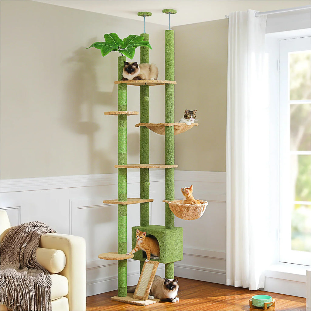 Tall floor-to-ceiling multi-level cat tree with green platforms and sisal scratching posts in a cozy living room.