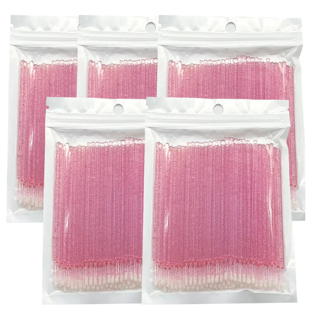 A set of five clear resealable bags filled with pink glittery disposable eyelash cleaning microbrushes.