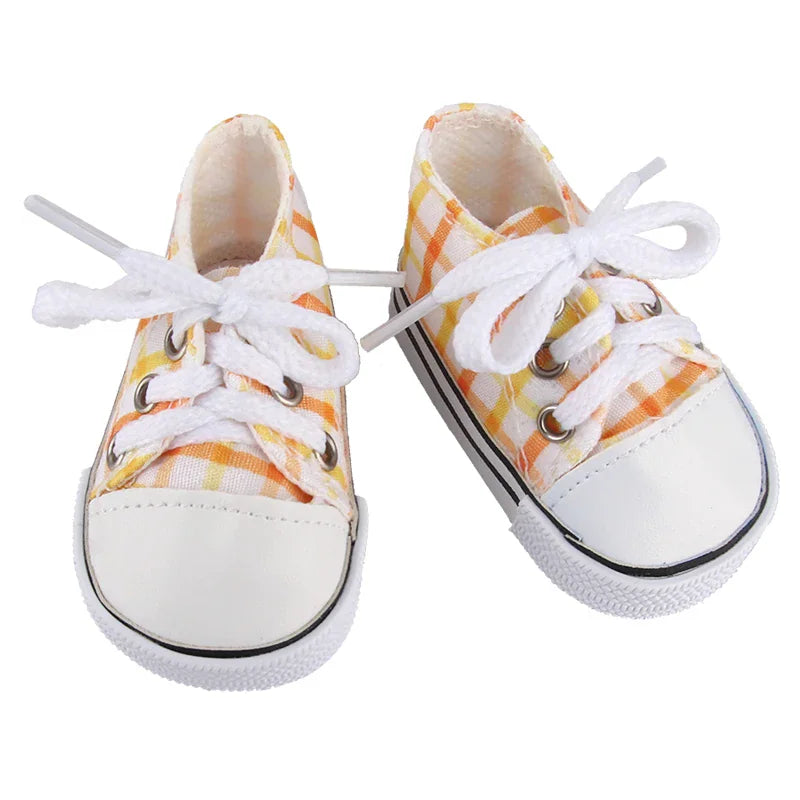 A pair of yellow and white checkered canvas doll sneakers with white laces and rounded rubber toes.
