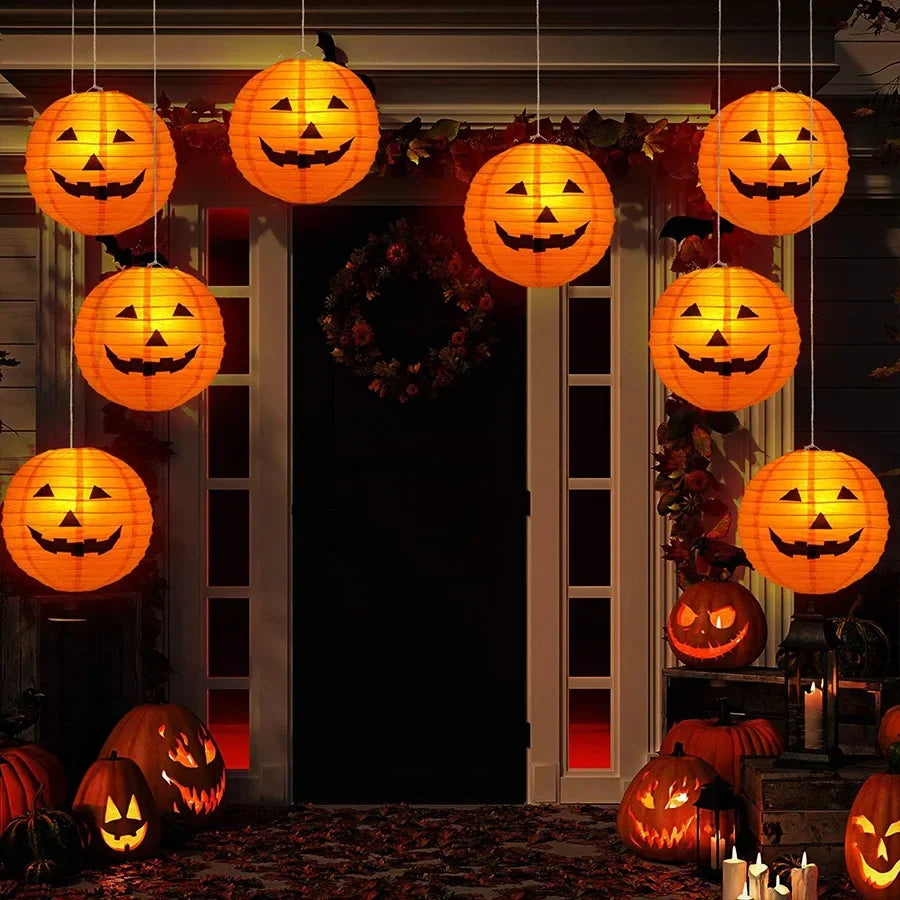 Orange jack-o'-lantern paper lanterns hanging as Halloween decorations on a house porch