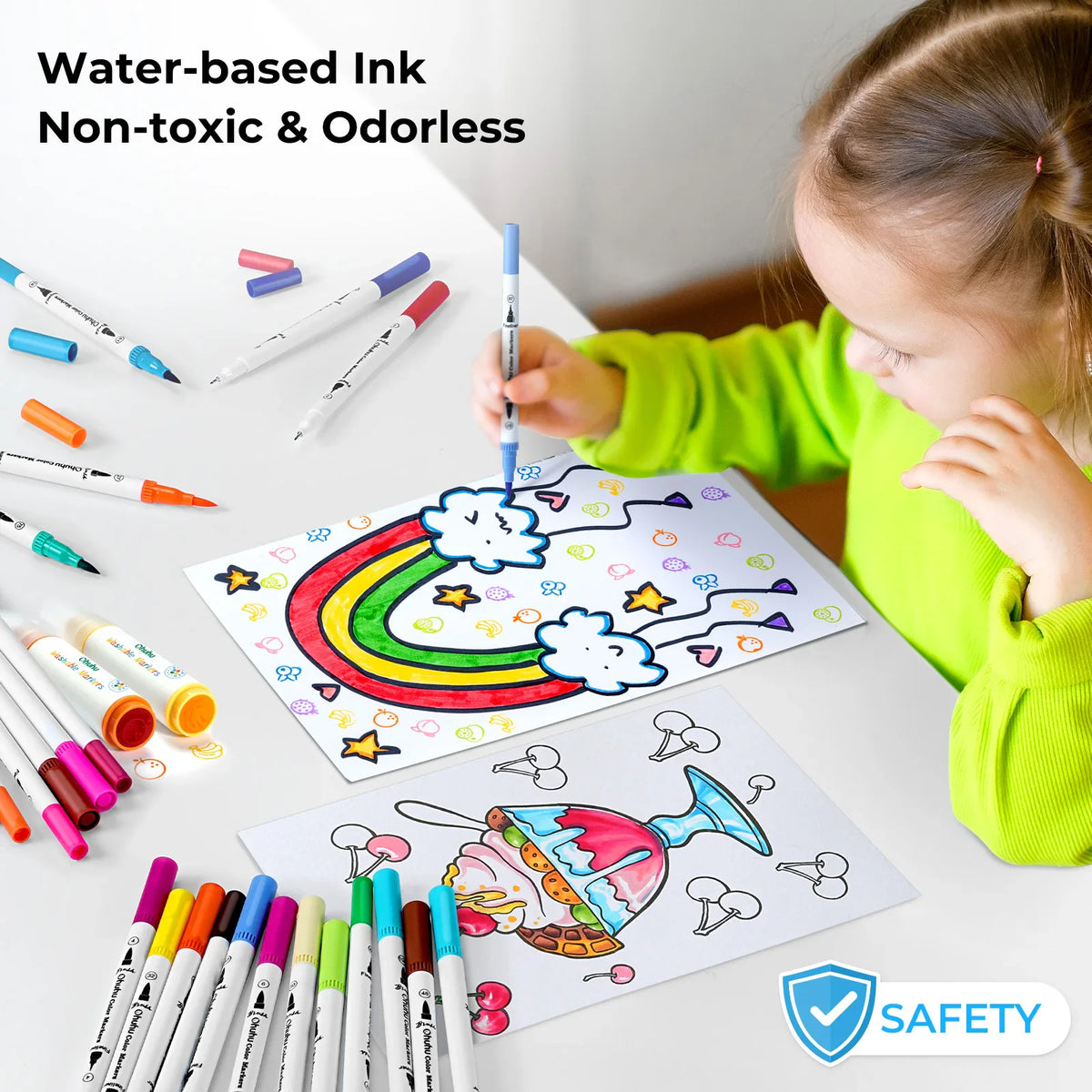 A child drawing a rainbow on paper with a blue dual-tip marker, surrounded by various coloured pens.
