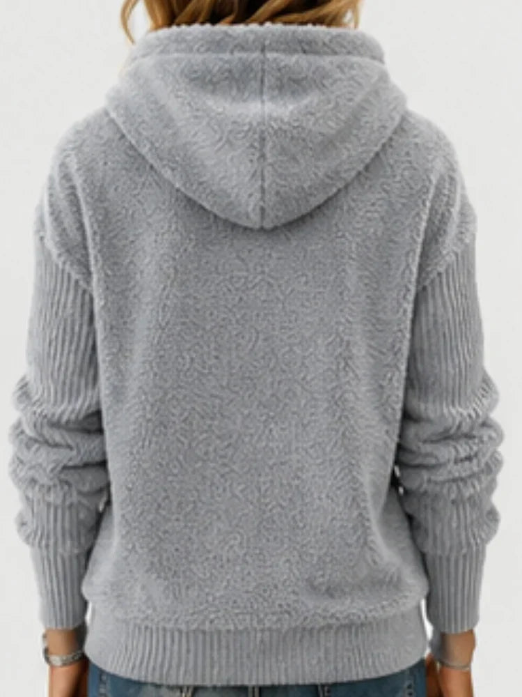 The back view of a gray fuzzy fleece half-zip hoodie with a hood and ribbed sleeves.