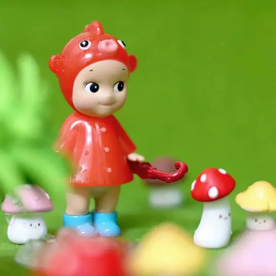 Small collectible doll figurine in a red fish hat and raincoat with small decorative mushrooms