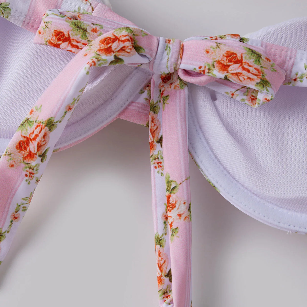 Close-up of bikini top center with bow detail and floral striped pattern