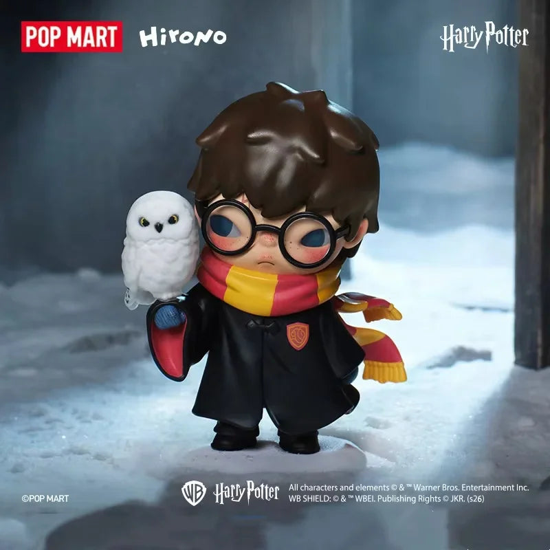 Small figurine of a character with round glasses and a scarf holding a white owl in a snowy setting