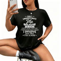 A woman wearing a black short-sleeved t-shirt with a white quote print on the front