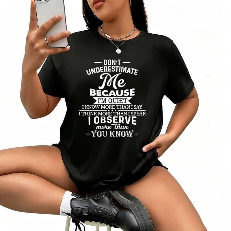 A woman wearing a black short-sleeved t-shirt with a white quote print on the front