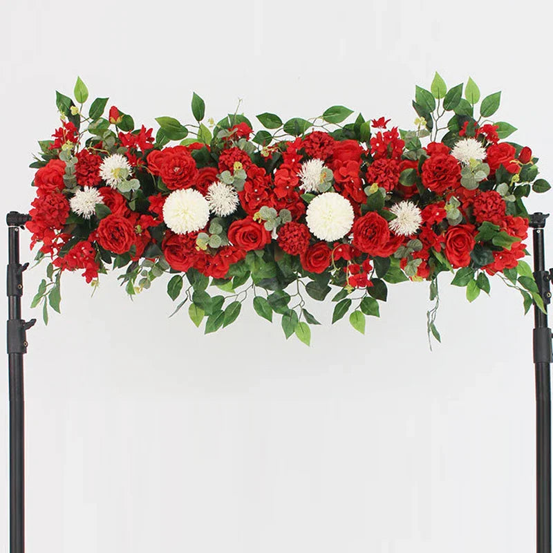 Red artificial rose and greenery floral centerpiece row on a wedding arch stand