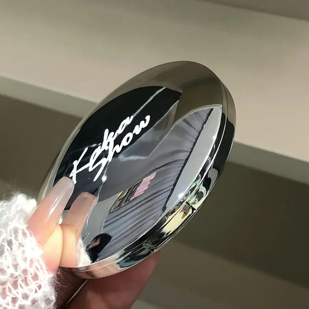 Silver metallic highlighter compact closed with branding on the lid