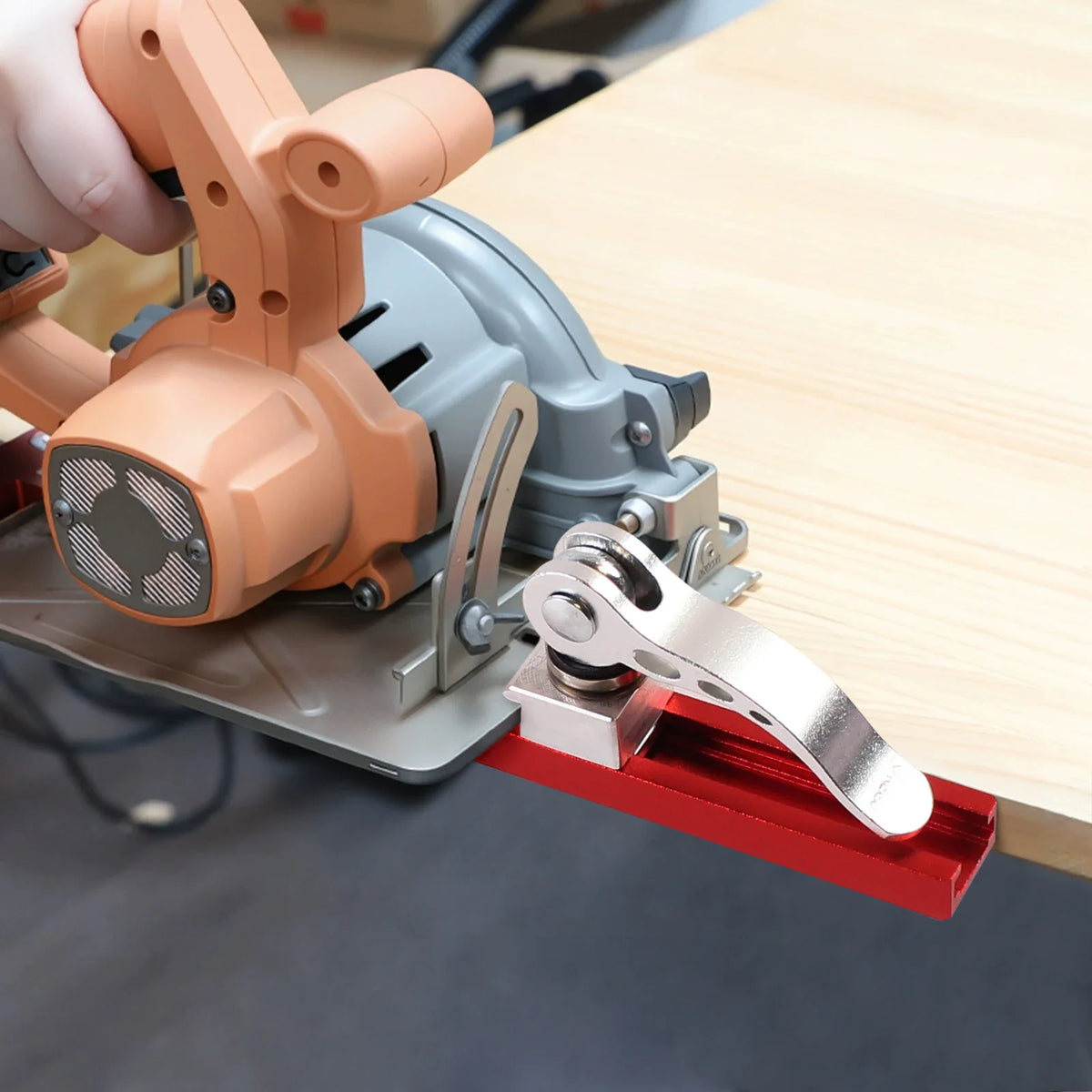 Circular saw with red guide rail being held on wooden board
