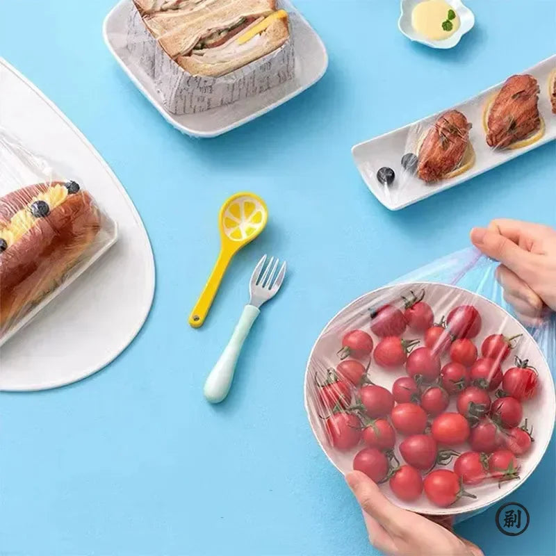 Assorted food items covered with disposable elastic plastic wraps on a blue background